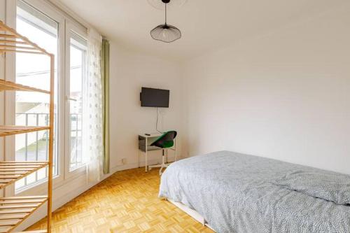 une chambre avec un lit, un bureau et une fenêtre dans l'établissement appartement proche paris et Roissy, à Persan