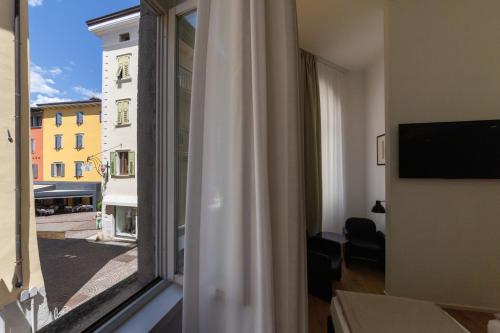 a room with a window with a view of a building at Hotel Lago Di Garda in Nago-Torbole