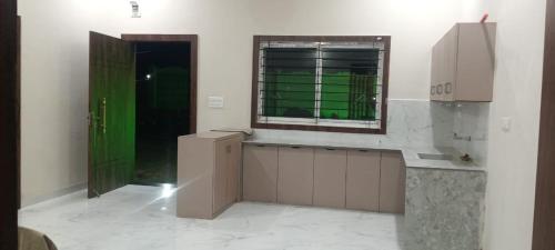 a kitchen with a green door and a window at Nirvan Stays with Pool ,Indore Bhopal Highway 