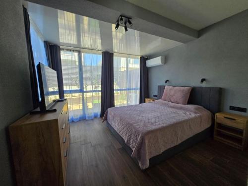 a bedroom with a bed and a large window at villa Amethyst in Lozenets