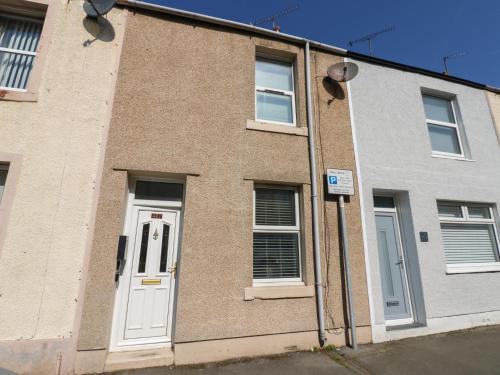 a brick building with a white door and windows at Lonsdale Street in Workington