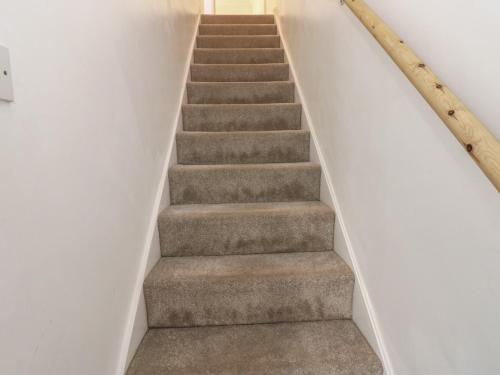 a staircase in a house with white walls and carpet at Lonsdale Street in Workington