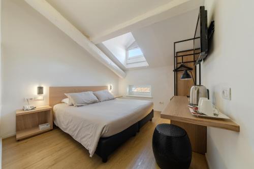 a bedroom with a bed and a tv on a wall at Hotel Lago Di Garda in Nago-Torbole