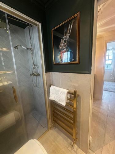 a bathroom with a shower and a picture of a rabbit on the wall at Cosy Seaside Cottage in Brighton & Hove