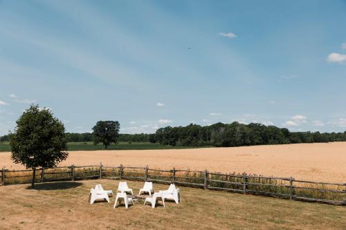 a group of white chairs sitting in front of a field at Babcock-Hubbs House in Carrying Place