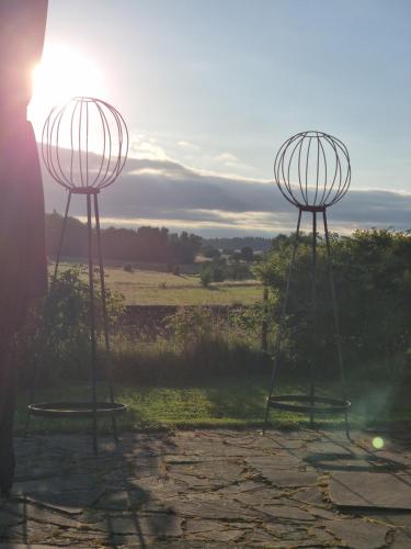 two metal objects sitting on top of a field at charmant groot huis met verzicht en zonsondergang aan voet van de Ardennen in Mettet