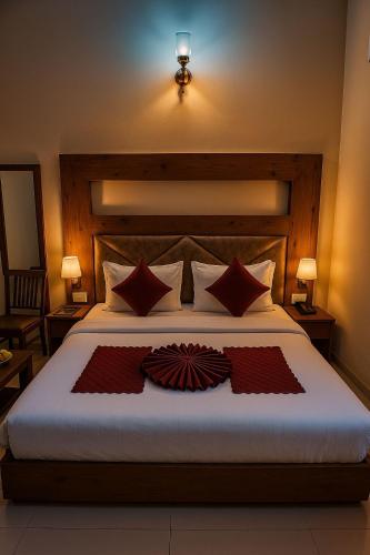 a bedroom with a large bed with red pillows at Hotel Woodlark Zirakpur II A Peaceful Stay I Travelers Choice I Best for Family and Group in Chandīgarh