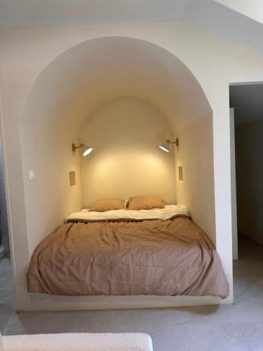 a bedroom with a bed in a white room at Studio Santorin in Périgueux