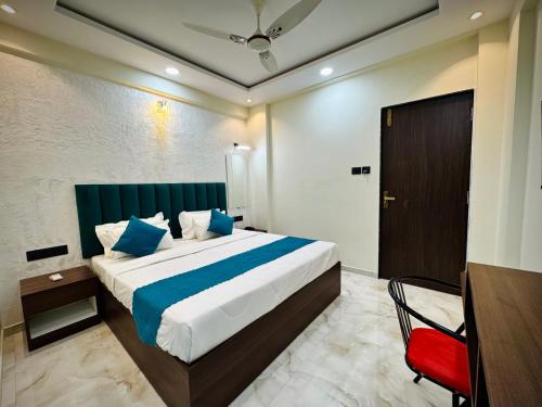 a bedroom with a large bed and a red chair at Hotel Vanvira in Lonavala