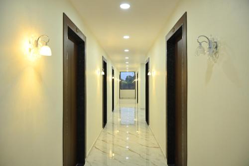 a hallway with two lights and a tile floor at Hotel Vanvira in Lonavala