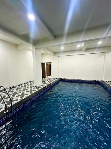 a swimming pool with blue water in a building at Hotel Vanvira in Lonavala