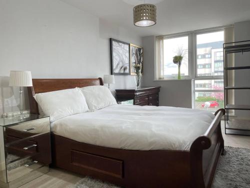 a bedroom with a bed and a desk and windows at Spacious, smart apartment near City Centre and Coop Arena Free parking in Manchester