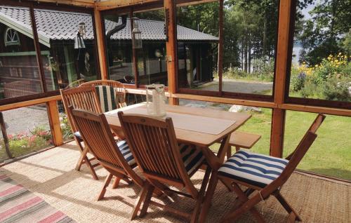 a wooden table and chairs on a screened porch at Naturskönt boende med tillgång till båt in Vrigstad