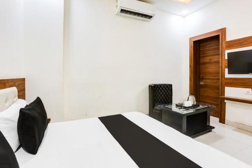 a bedroom with a bed and a desk and a television at Super Hotel O Green in Hisār