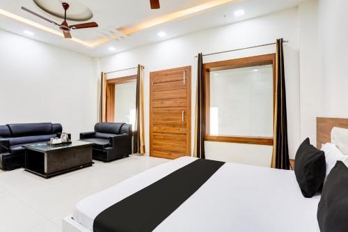 a bedroom with a bed and two chairs and a table at Super Hotel O Green in Hisār