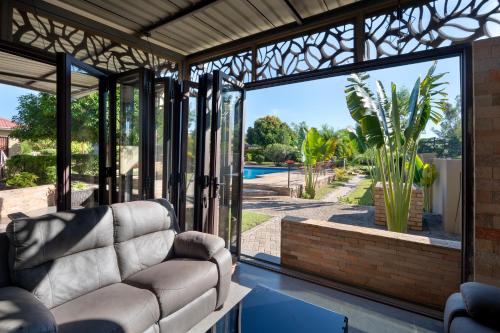 a living room with large glass doors and a couch at Nzubo Experience in Livingstone
