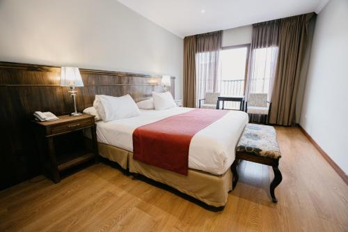a hotel room with a large bed and a window at Chalten Suites Hotel in El Chalten