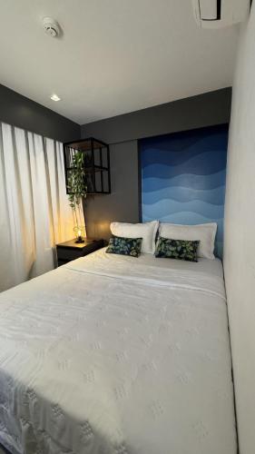 a bedroom with a large white bed with two pillows at Wanderlust Hostel in Maceió