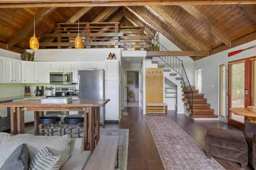 a kitchen and living room with a wooden ceiling at Whispers on the Sandy in Rhododendron