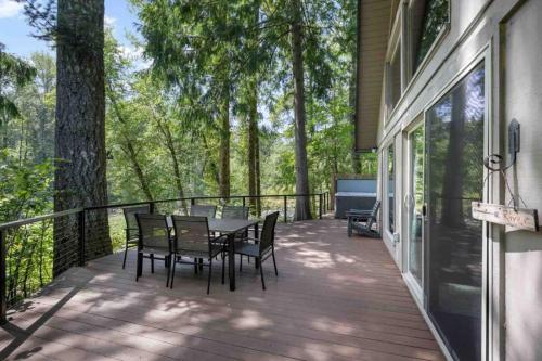 a deck with a table and chairs on a house at Whispers on the Sandy in Rhododendron
