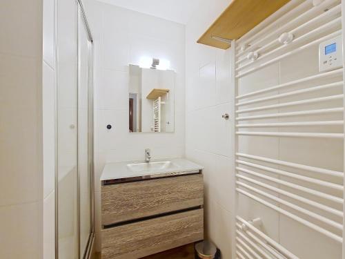 une salle de bain blanche avec un lavabo et un miroir dans l'établissement SOLARIUM SR11 COSY & VIEW 5 pers, à Châtel