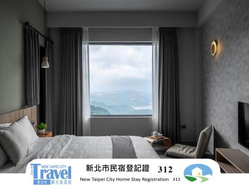 a bedroom with a bed and a large window at Two Easy Inn in Jiufen