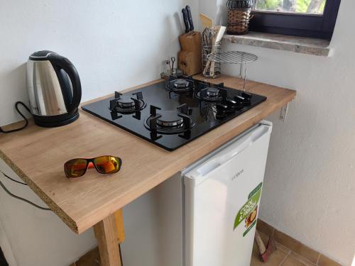 a kitchen counter with a stove and sunglasses on it at SunsetHouse Garden Apartment in Banka