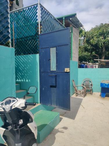 a motorcycle parked in front of a blue door at Casa Andres in San Juan La Laguna
