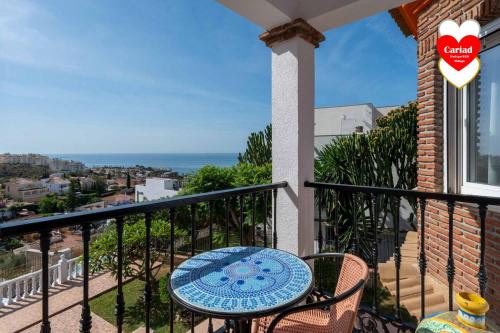 a balcony with a table and chairs and the ocean at Cariad Boutique Bed & Breakfast in Cala del Moral