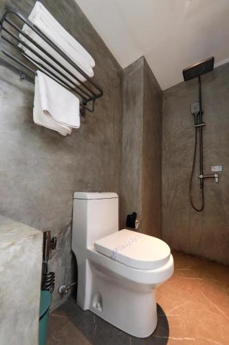 a bathroom with a toilet and a shower and towels at The Selene city hotel in Kandy