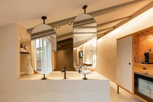 a bathroom with two mirrors on the wall at Premium Activehotel Bergkönig in Neustift im Stubaital