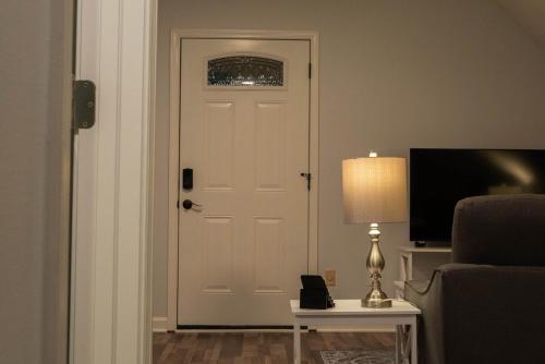 a white door in a living room with a lamp at Beautiful Luxury Studio Suite in Lawrenceville