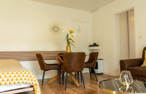 a living room with a table and chairs and a couch at Le SOLEIL D OR à 10 minutes de Nigloland in Bar-sur-Aube