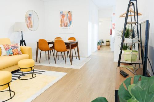a living room with a yellow couch and a table at Carcavelos Beach 12 in Carcavelos