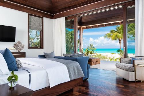 a bedroom with a bed and a view of the ocean at Beautifully Caribbean villa with captivating beach and clear blue waters in Leeward