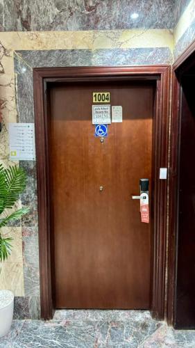 a brown door with a sign on top of it at فندق صفوة المشاعر in Al Khansāk