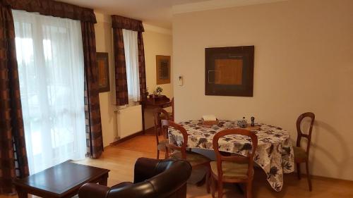 ein Esszimmer mit einem Tisch und Stühlen in einem Raum in der Unterkunft Andante apartman in Bük