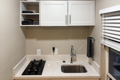 a kitchen with a sink and white cabinets at Perris Tiny Home Paradise in Perris
