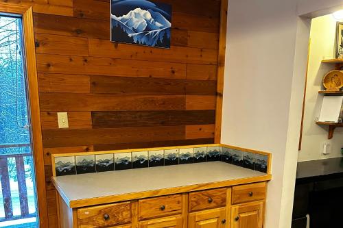 a kitchen with a wooden wall with a counter at Gstaad House in Girdwood