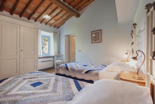 a bedroom with two beds and a window at Tregole in Castellina in Chianti