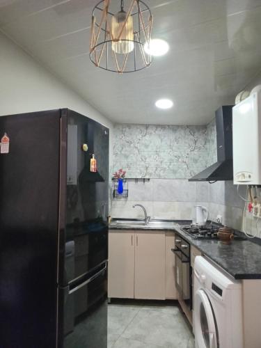 a kitchen with a black refrigerator and a sink at Apartment Old Tbilisi in Tbilisi City