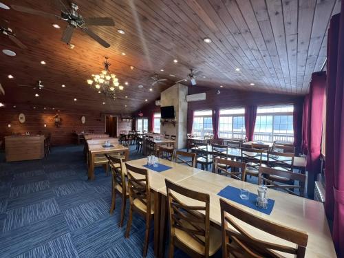 a restaurant with wooden ceilings and tables and chairs at Ahmic Lake Resort in Magnetawan