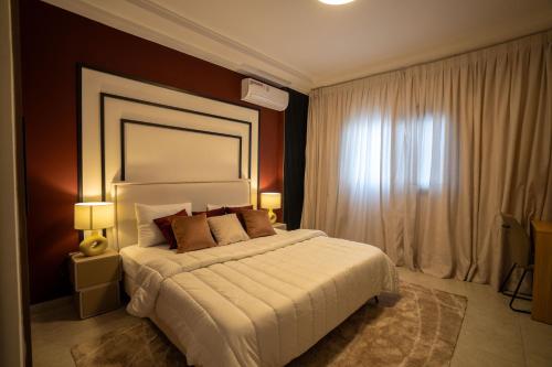 una camera da letto con un letto, due lampade e una finestra di Teranga Baobab a Dakar