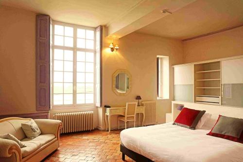 a bedroom with a bed and a couch and a chair at Hôtel Le Relais Louis XI in Meung-sur-Loire