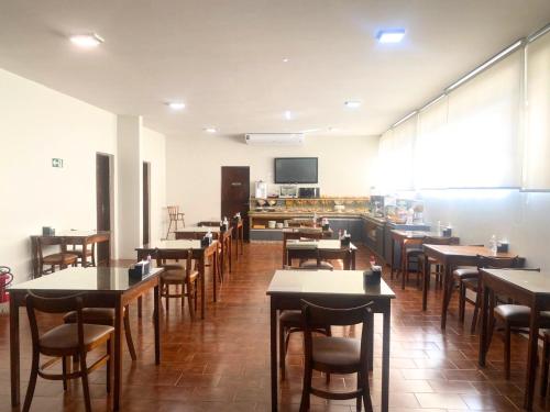 una sala da pranzo con tavoli e sedie di Santa Rosa Hotel a Assis