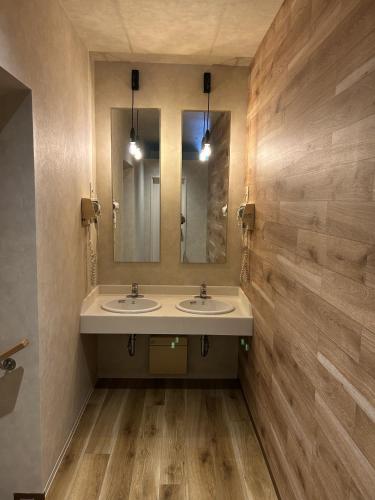 a bathroom with two sinks and a mirror at Capsule Inn Osaka (Male Only) in Osaka