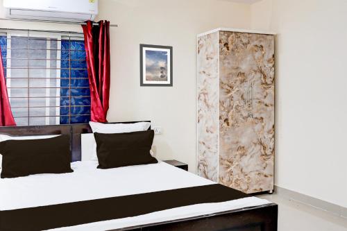 a bedroom with a bed and a red curtain at Hotel O Shivay Inn Ayodhaya Bypass Road in Bhopal