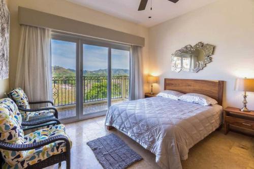 a bedroom with a bed and a balcony with a view at Acqua 801 in Jacó