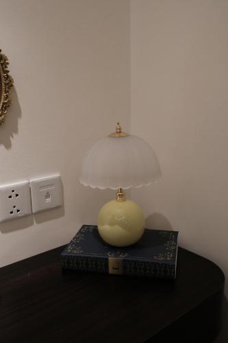 a lamp on top of a book on a table at Best Western Premier Sapphire Hạ Long 2BR Homestay 55m2 in Ha Long
