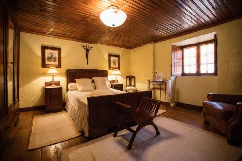 ein Schlafzimmer mit einem Bett und einem Stuhl darin in der Unterkunft Quinta da Azenha by House and People in Valdosende